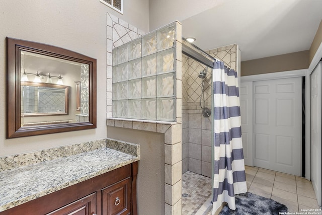 bathroom featuring walk in shower, tile patterned flooring, and vanity