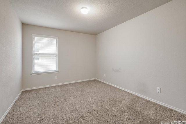 carpeted empty room with a textured ceiling