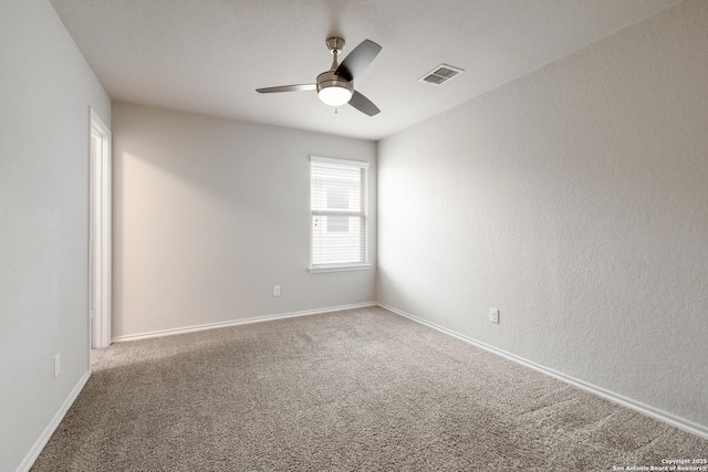 empty room featuring ceiling fan and carpet