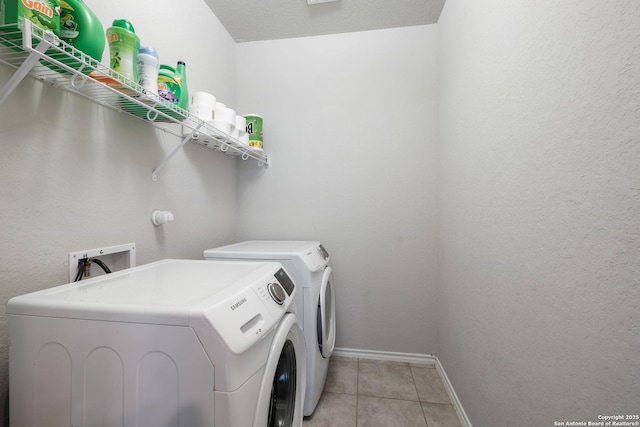 washroom with washer and dryer and light tile patterned floors