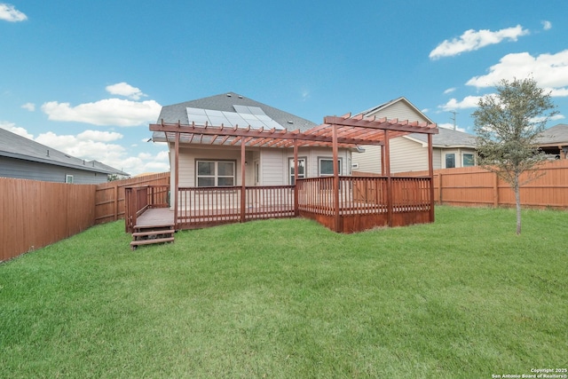 rear view of property featuring a lawn, a pergola, and a wooden deck