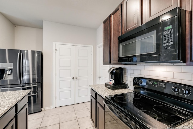 kitchen featuring black appliances, dark brown cabinets, light tile patterned flooring, and light stone counters