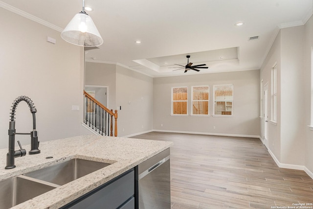 kitchen with sink, dishwasher, decorative light fixtures, and a tray ceiling