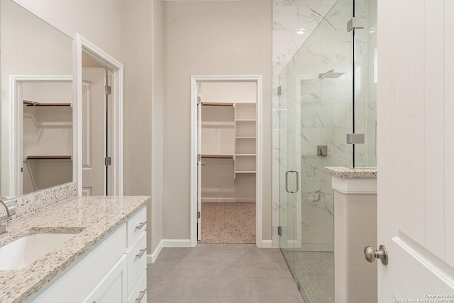 bathroom with a shower with shower door and vanity