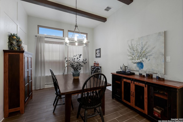 dining area featuring beamed ceiling and a notable chandelier