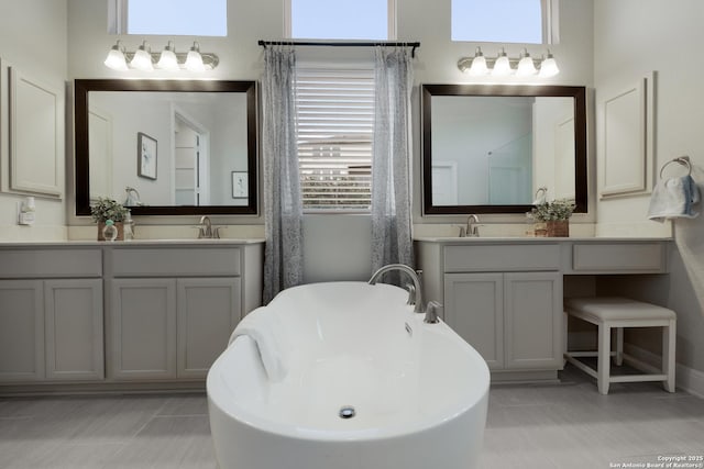 bathroom with vanity, tile patterned flooring, and a bathtub