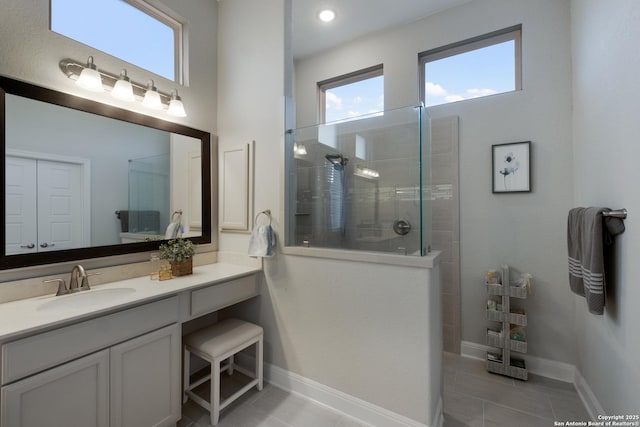 bathroom with vanity, tile patterned flooring, and a tile shower