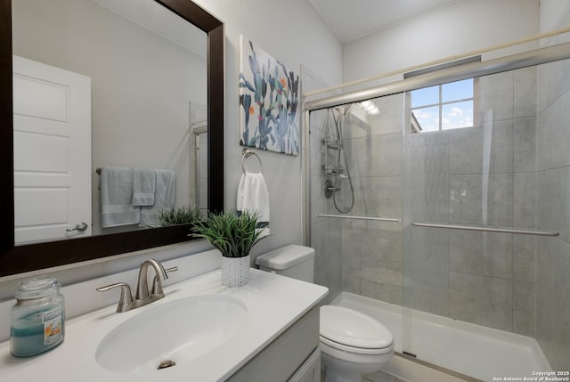 bathroom featuring walk in shower, vanity, and toilet