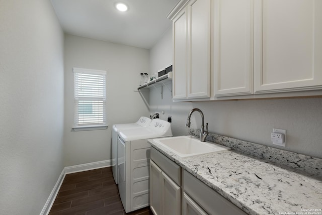 laundry area featuring cabinets, washing machine and dryer, and sink