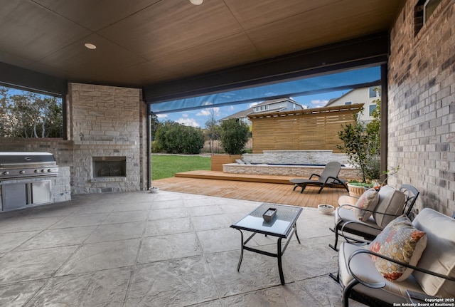 view of patio featuring area for grilling and an outdoor stone fireplace