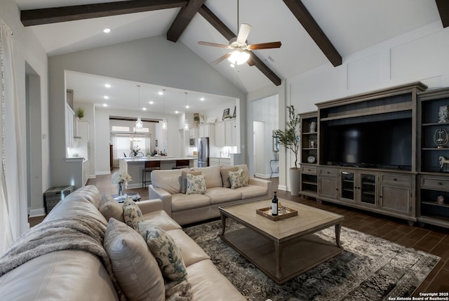 living room with ceiling fan, dark wood-type flooring, high vaulted ceiling, and beamed ceiling