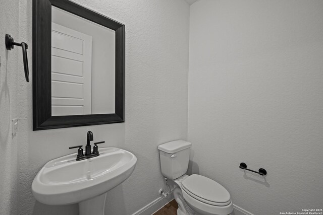 9314 Everly Crk, San Antonio, TX 78263 - bathroom featuring baseboards, a sink, and toilet