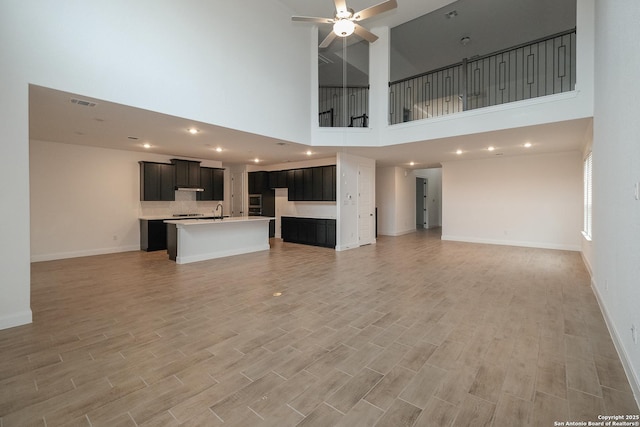 9314 Everly Crk, San Antonio, TX 78263 - unfurnished living room featuring baseboards, a sink, light wood-style floors, visible vents, and a ceiling fan
