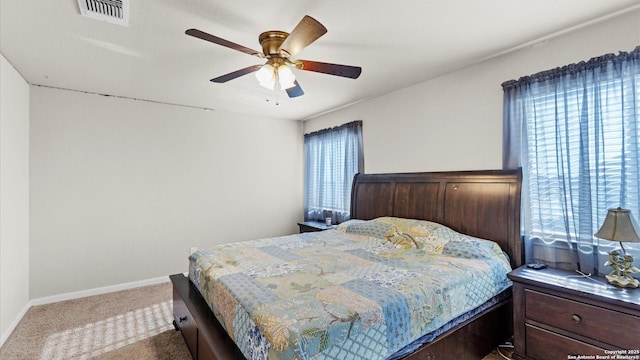 bedroom with multiple windows, ceiling fan, and carpet