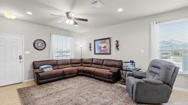 living room featuring ceiling fan, light tile patterned flooring, and a healthy amount of sunlight