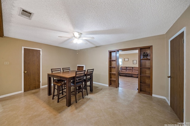 dining room featuring ceiling fan, a textured ceiling, and light tile patterned floors