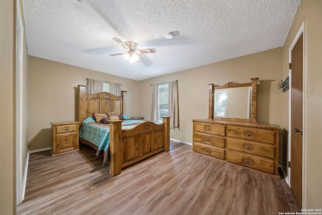 bedroom featuring a textured ceiling, ceiling fan, and light hardwood / wood-style flooring