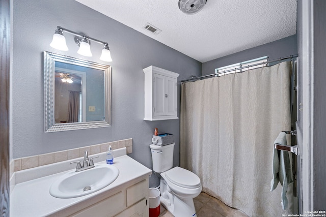 bathroom with a textured ceiling, tile patterned floors, vanity, and toilet