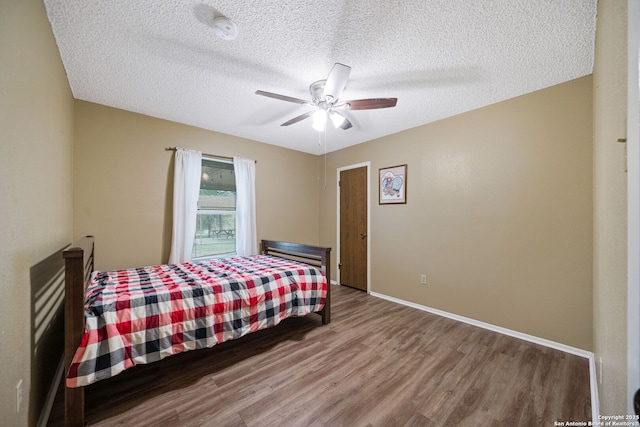 bedroom with ceiling fan, a textured ceiling, and hardwood / wood-style flooring