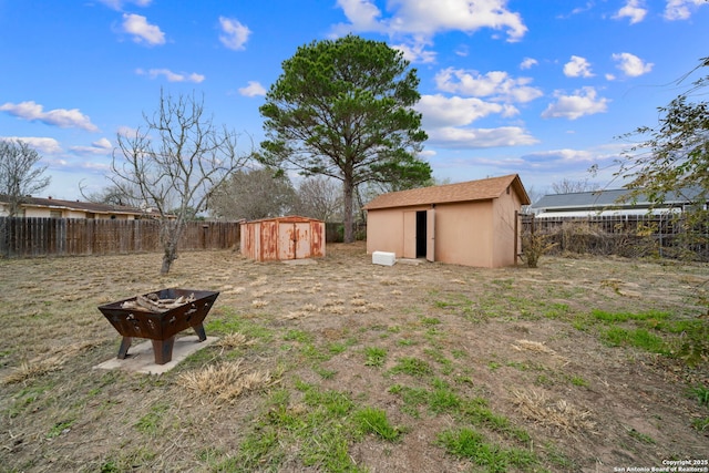 view of yard with a fire pit and a storage shed