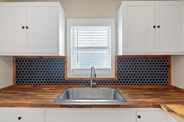 kitchen with white cabinets and butcher block counters