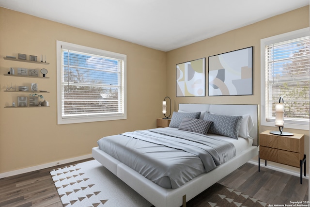 bedroom with dark wood-type flooring and multiple windows