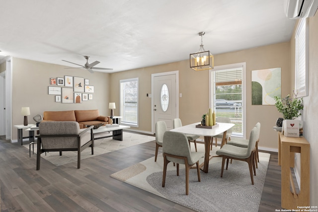 dining space with ceiling fan with notable chandelier, hardwood / wood-style flooring, and a wall mounted air conditioner