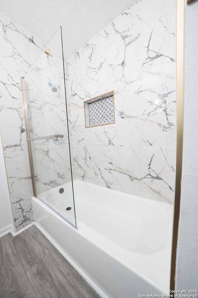 bathroom with tiled shower / bath and wood-type flooring