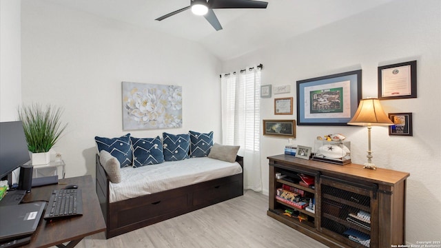 living room with ceiling fan, vaulted ceiling, and light hardwood / wood-style flooring