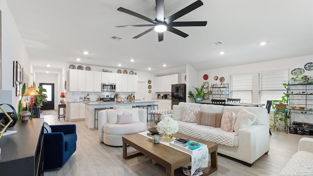 living room featuring ceiling fan and light hardwood / wood-style floors