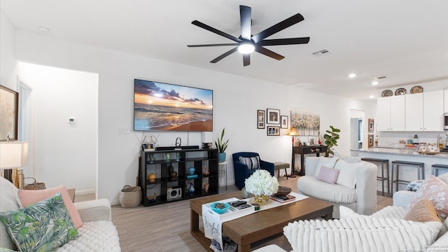 living room with ceiling fan and light wood-type flooring