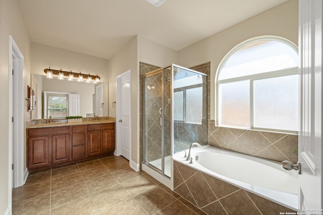 bathroom featuring shower with separate bathtub, vanity, and tile patterned flooring