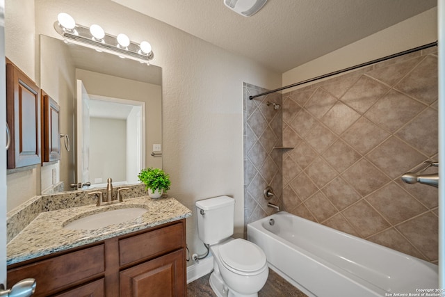 full bathroom with toilet, vanity, a textured ceiling, and tiled shower / bath combo