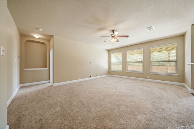 carpeted empty room featuring ceiling fan and a textured ceiling