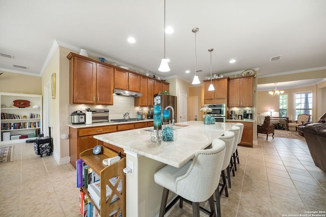 kitchen featuring pendant lighting, an island with sink, light tile patterned floors, a breakfast bar, and sink