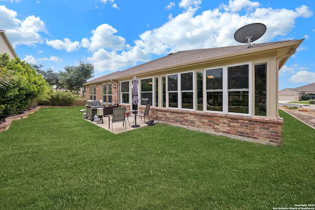 rear view of house with a patio area and a lawn