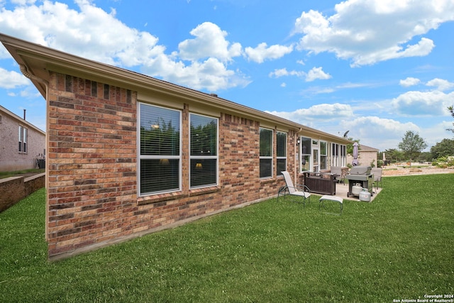 back of house featuring a patio area, a lawn, and central AC