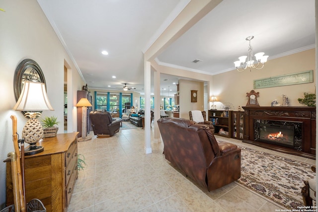 tiled living room with ornamental molding, ceiling fan with notable chandelier, and a fireplace