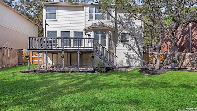 rear view of property with a yard and a wooden deck