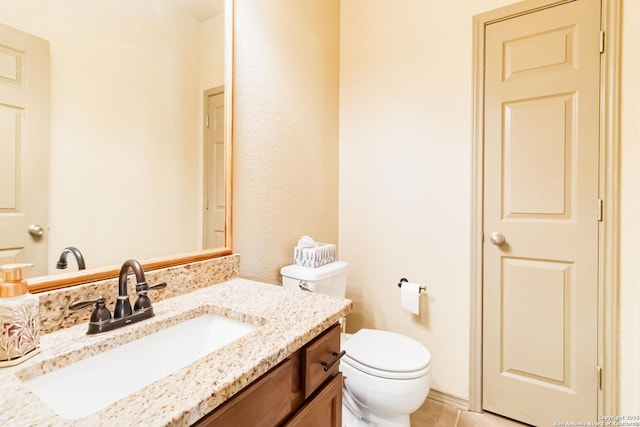 bathroom with tile patterned flooring, vanity, and toilet