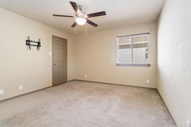 carpeted spare room featuring ceiling fan