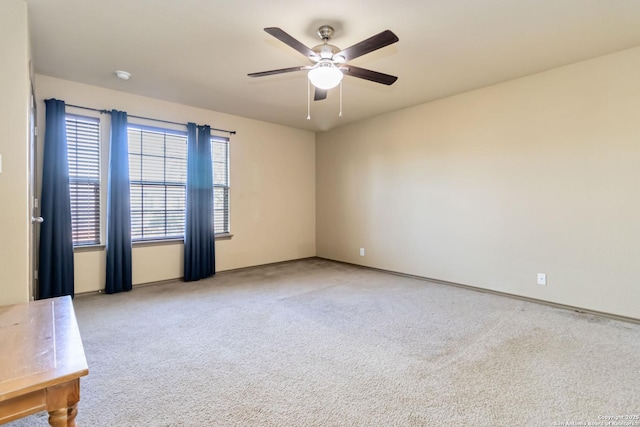 carpeted spare room with ceiling fan