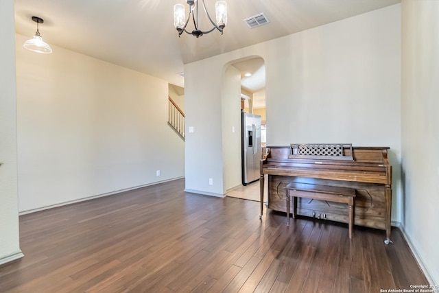 misc room featuring dark wood-type flooring and a chandelier