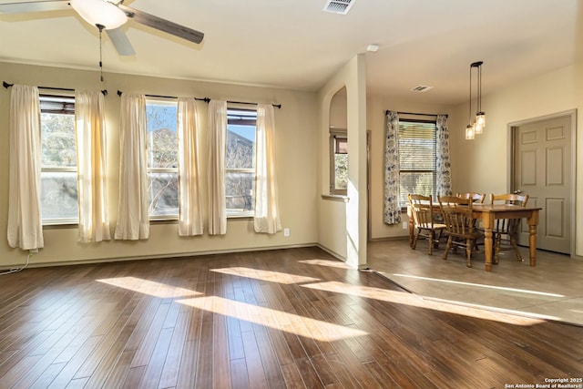 dining area with dark wood-type flooring, ceiling fan, and a wealth of natural light