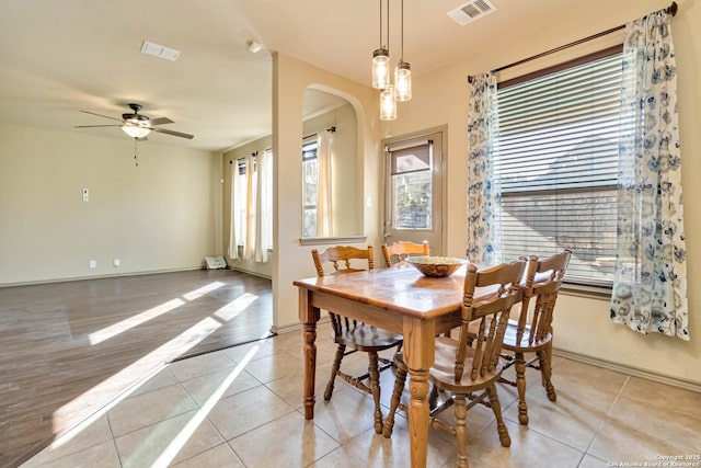 tiled dining area with ceiling fan and a wealth of natural light