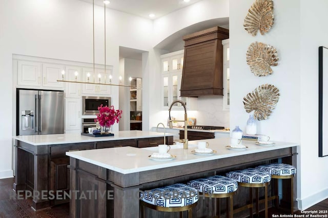 kitchen featuring white cabinets, pendant lighting, high quality fridge, and dark wood-type flooring