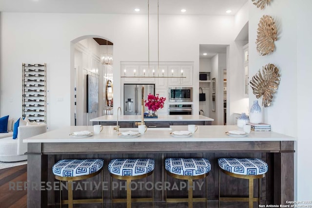 435 Nash, New Braunfels, TX 78130 - kitchen featuring a chandelier, decorative light fixtures, stainless steel appliances, a breakfast bar area, and white cabinetry