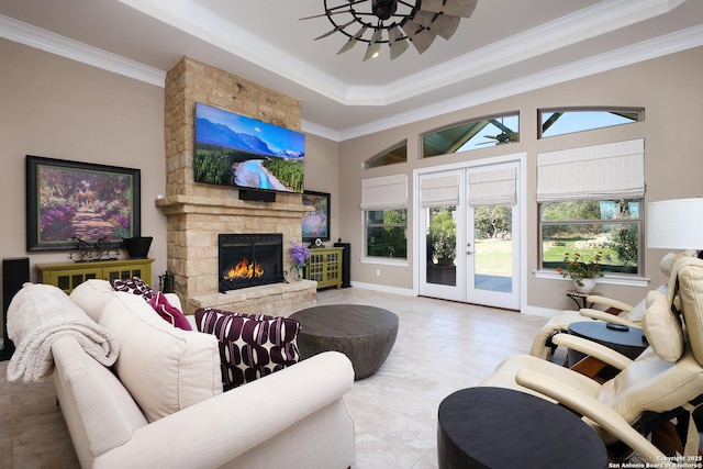 tiled living room with french doors, a raised ceiling, crown molding, and a fireplace