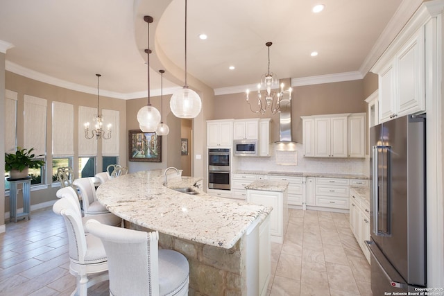 kitchen with stainless steel appliances, sink, a large island, white cabinets, and decorative backsplash