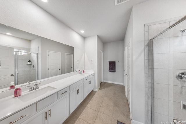 bathroom with tile patterned flooring, a shower with shower door, and vanity